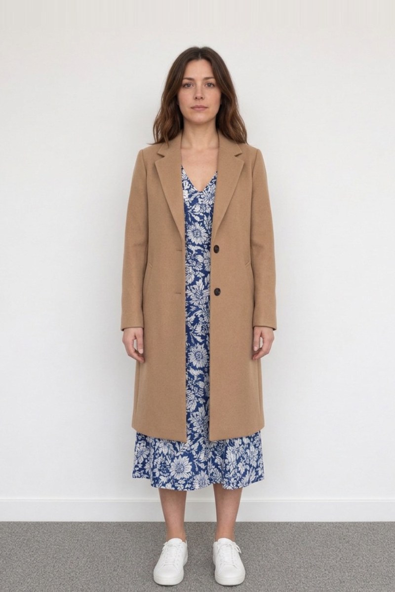 A camel coat over a blue floral midi dress