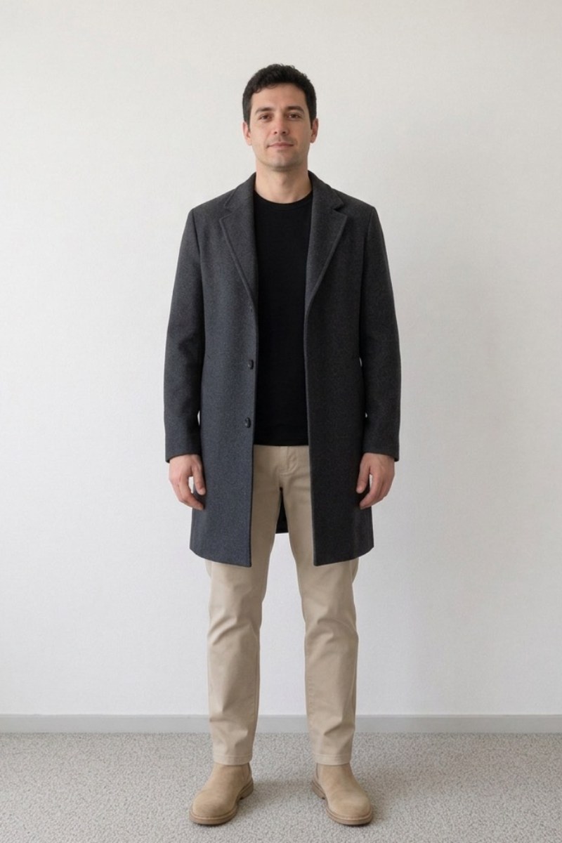 A grey overcoat over a black jumper and stone chinos